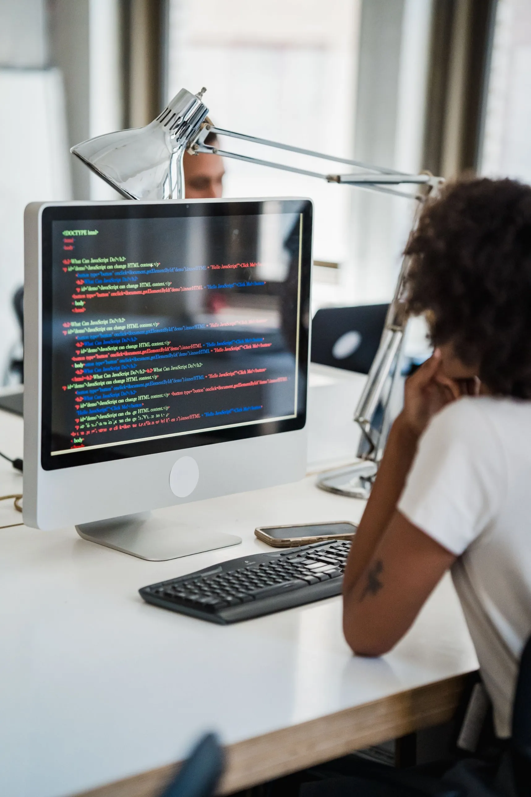 Sviluppatrice osserva il codice di un software su un monitor