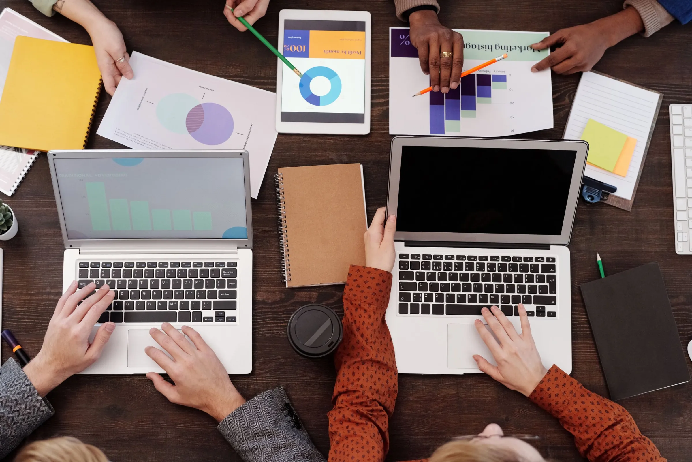 Team al lavoro con portatili, tablet e grafici di analisi visti dall’alto